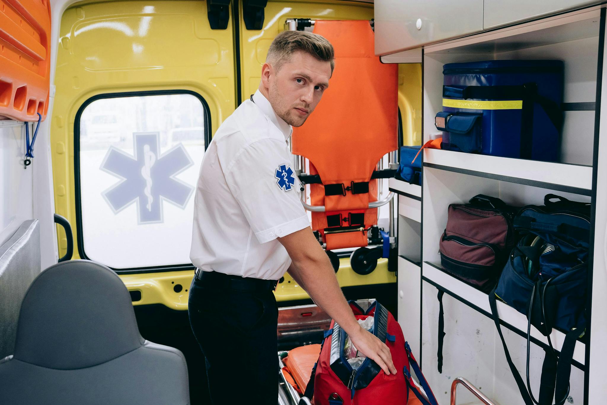 A paramedic organizes medical supplies inside an ambulance, ensuring readiness for emergencies.
