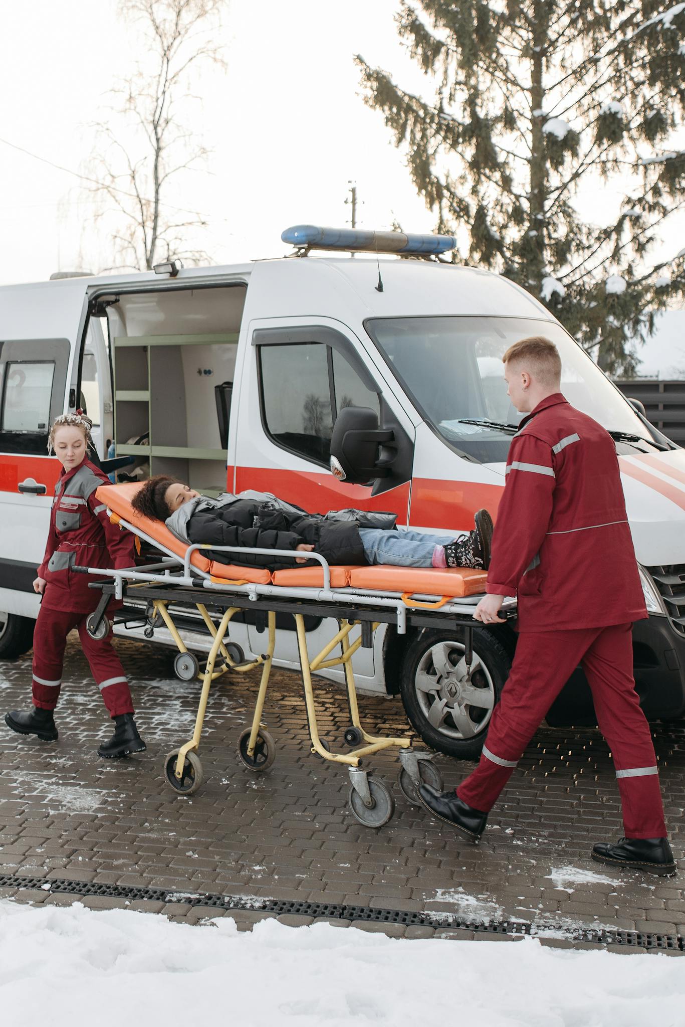 Paramedics transferring a patient on a stretcher to an ambulance for emergency care.